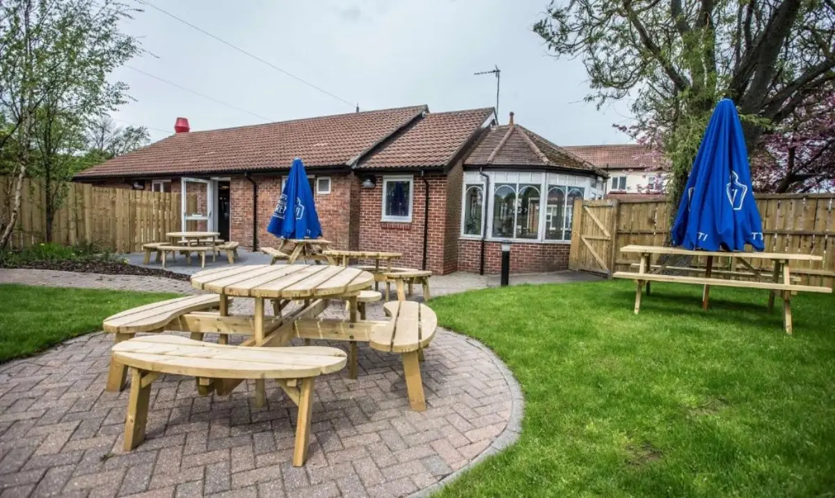 Garden area at Hotel 52 Stanley with picnic tables and parasols